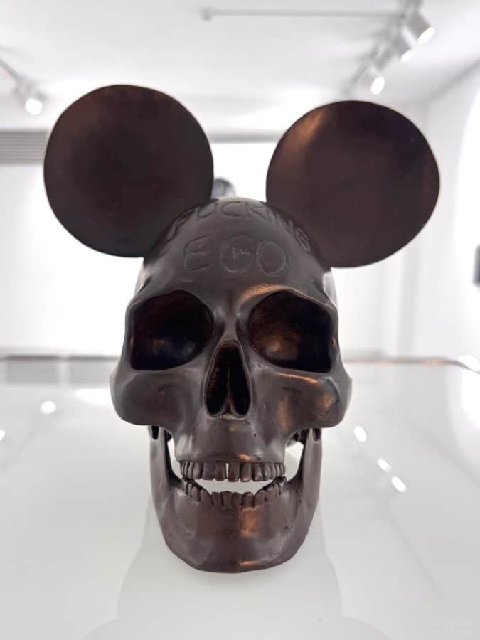 Fucking Ego by Beto Gatti, bronze sculpture of a human skull with two large round ears and the words "FUCKING EGO" across the forehead, 2020