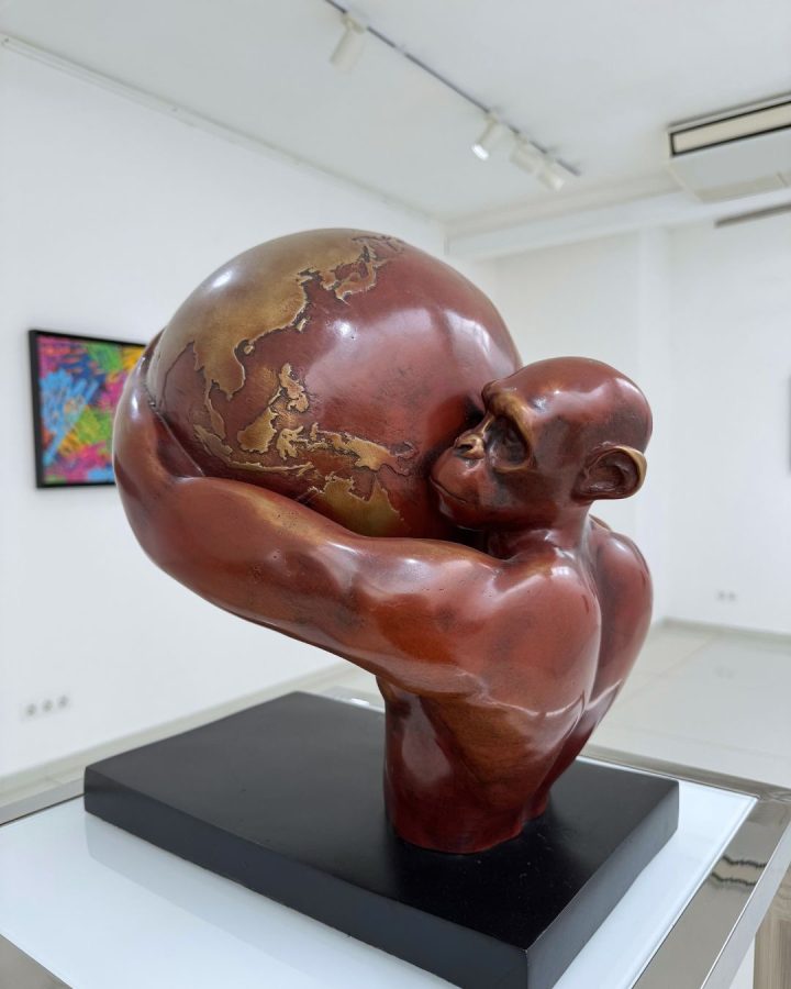 Human Rights by Beto Gatti, red-patina bronze sculpture of a primate figure embracing a globe with golden continents, 2021