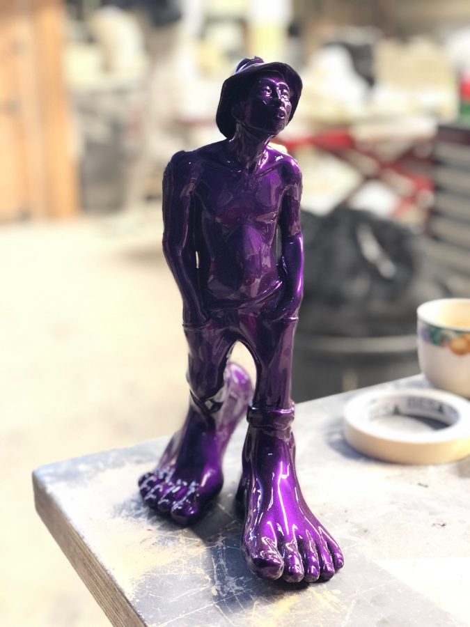 Le Siffleur XS by Idan Zareski, high-gloss purple resin sculpture of a whistling man in a bucket hat, chin raised, standing on enormous bare feet