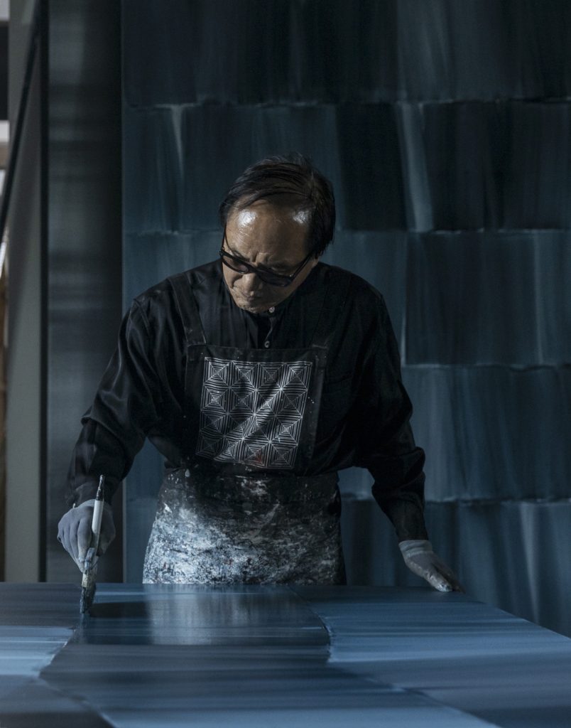 Shim Moon Seup painting a canvas of The Presentation series in his studio